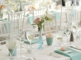 a neutral and mint wedding tablescape with mint vases and napkins, pink adn white blooms is very fresh and spring-like