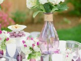 a lovely purple and white wedding tablescape with white and fuchsia blooms and greenery, purple glasses and napkins, lilac chargers is amazing