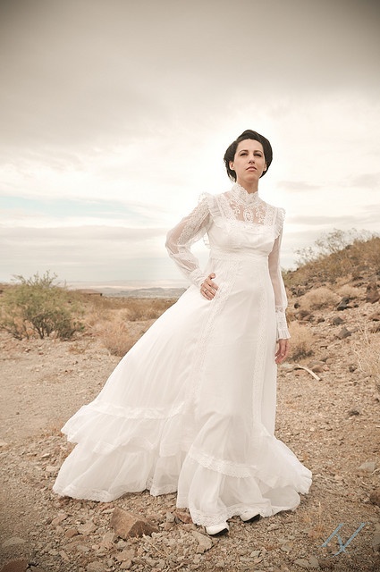 a refined lace vintage wedding dress with an illusion turtleneckline, long sleeves, a ruffle skirt with a train is a lovely idea for a prairie bridal look