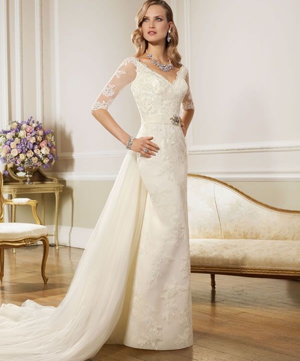 A refined lace fitting vintage wedding dress with a V neckline, short lace sleeves, an embellished sash with an additional long train for a statement and vintage elegance