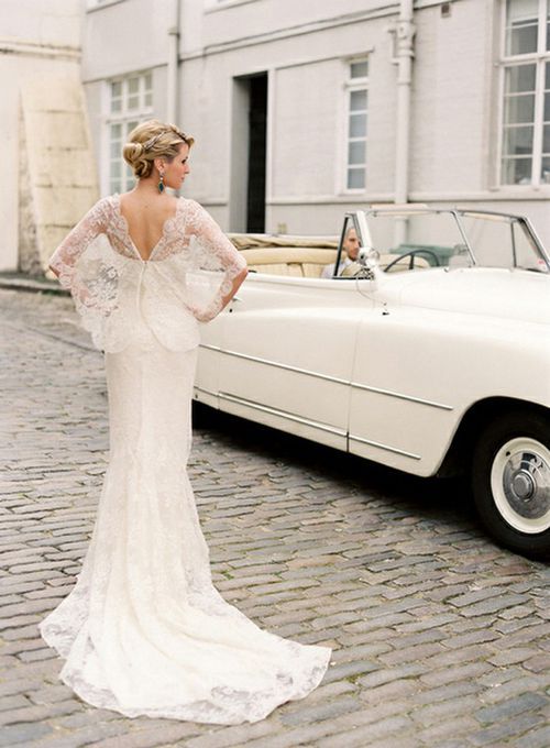 a vintage lace mermaid wedding dress with wide lace sleeves, a cutout back and a train is pure vintage elegance and beauty