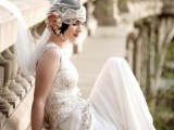 a sophisticated lace embellished 20s inspired wedding dress with a high neckline and no sleeves, a train and a cap veil for an accent
