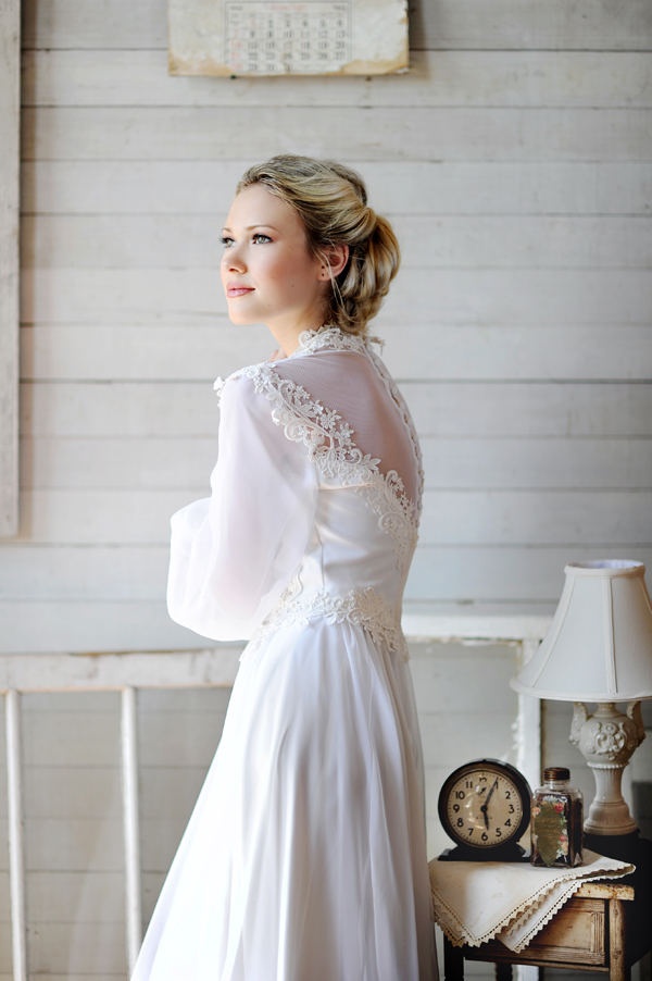a beautiful vintage A line wedding dress of plain fabric and lace, with puff sleeves, buttons on the back