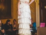a strapless 20s inspired lace wedding dress with ruffles, a train and a matching headband is a stylish idea to rock