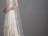a beautiful vintage champagne-colored A-line wedding dress with spaghetti straps, a tiered skirt with an embellished rim, a long veil and a train