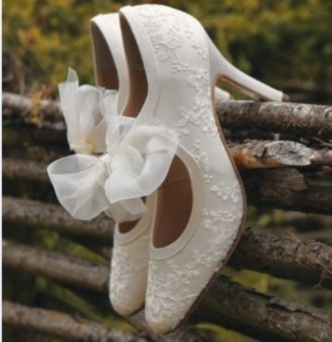 white lace cutout shoes with large bows look vintage and very sophisticated and bring a romantic feel