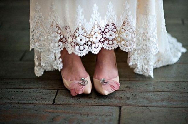 Vintage tan wedding shoes with embellishments and pink feathers add a refined and romantic touch to the look