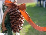 evergreens, a pinecones and a burlap bow are a nice posie to accent wedding chairs and your aisle