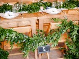 a greenery garland on the table and a matching one decorating the chairs to make the venue look fresh, bright and welcoming