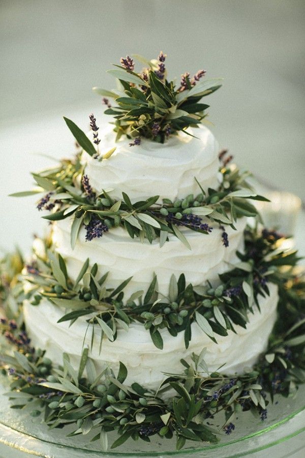 a white wedding cake decorated with lush greenery and lavender looks cool and won't cost you too much