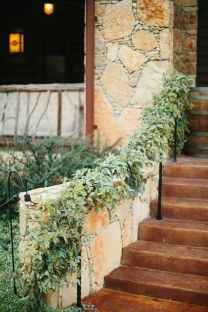 decorate the railing with lush greenery to make the wedding decor fresh and cool