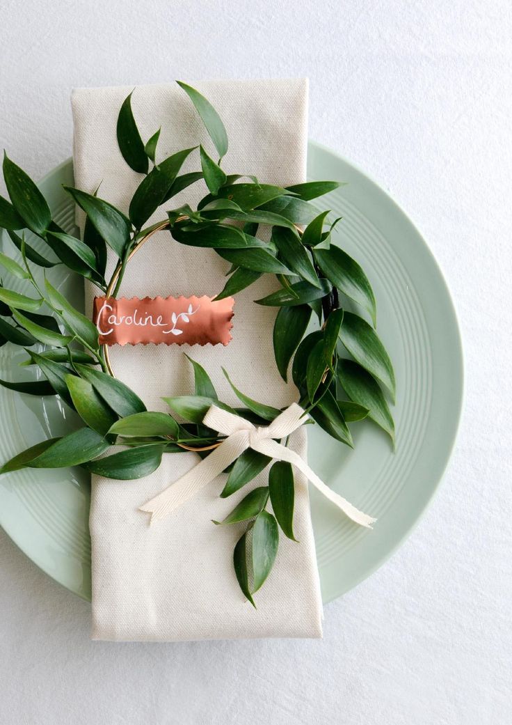 a simple greenery wreath with a bow will subtly and gently highlight your wedding place setting