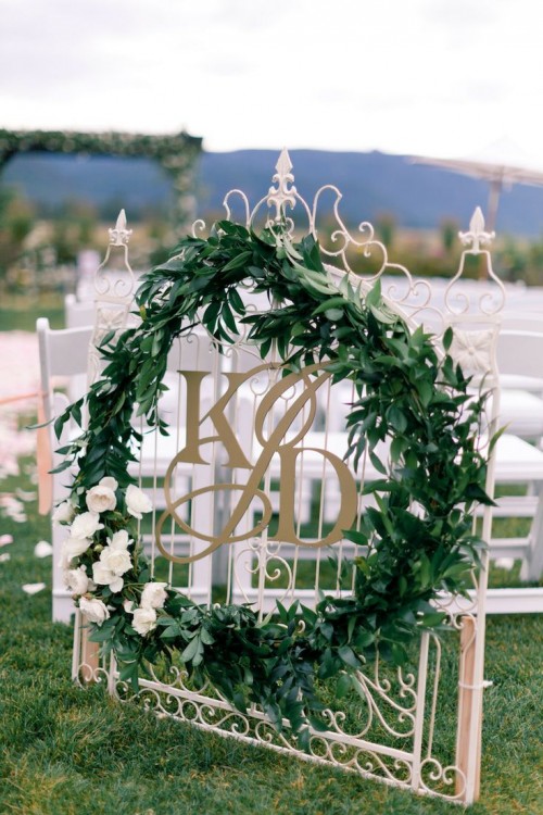a large greenery wreath with white blooms will highlight your ceremony space or venue to make it frehs and bold