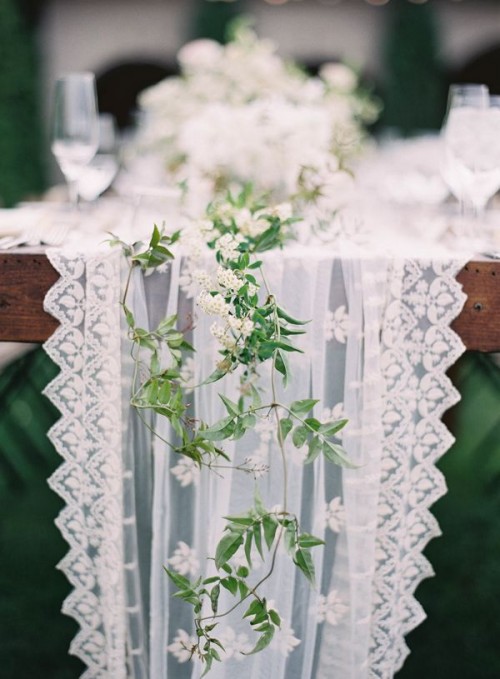 a white lace table runner paired with a greenery and white bloom one will make your table look fresh and ethereal