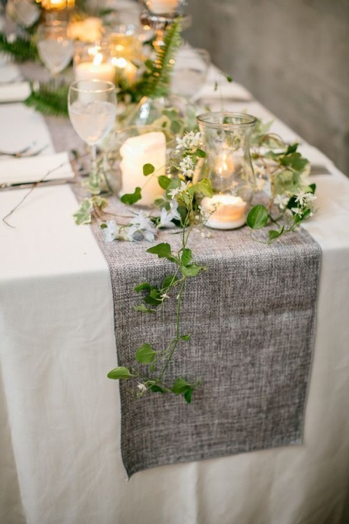 a grey burlap table runner with greenery and candles is a cool idea to refresh your wedding tablescape and make it more rustic