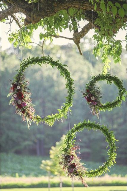 greenery and bold bloom wreaths hanging can be a nice wedding backdrop or a decoration for the venue