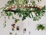 a greenery chandelier with lots of candles is a stylish idea to illuminate your space in a chic and cool way and add freshness to it