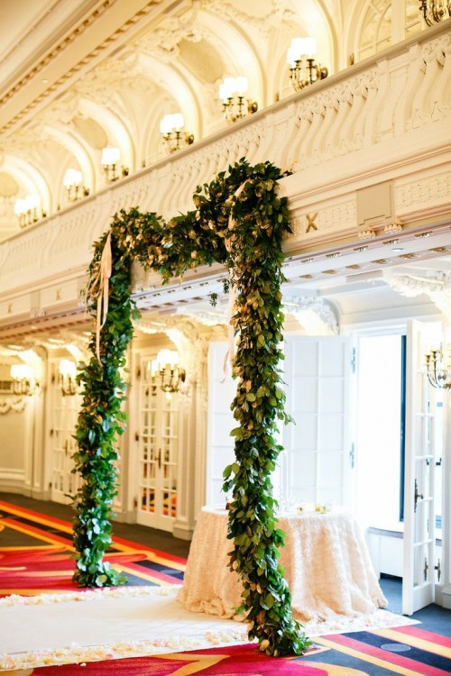 a creative wedding arch made of greenery and attached to the wall allows to have a ceremony without any problem everywhere