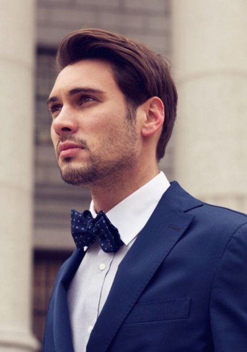 a navy suit, a white shirt and a navy printed bow tie create an elegant look with a contrasting touch