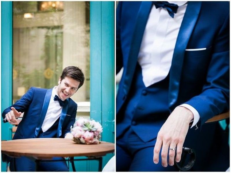 A navy three piece wedding suit with silk lapels, a waistcoat, a white shirt and a black bow tie