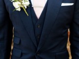 a navy three-piece suit, a white shirt, a blush tie plus a floral boutonniere
