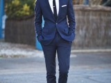 a navy suit, a white shirt, a black tie and black shoes for a modern to minimalist groom’s outfit