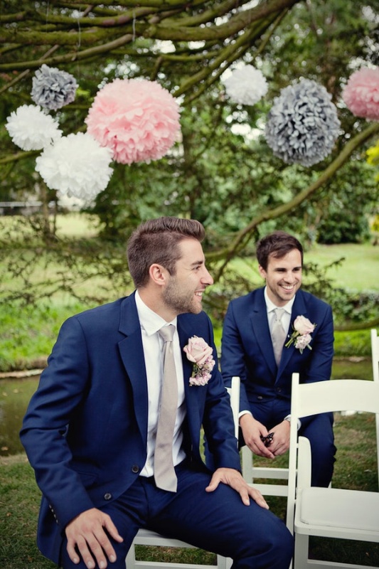 a navy suit, a white shirt, a grey tie and blush boutonnieres for a chic and elegant groom's look