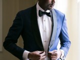 a super elegant navy tuxedo with black lapels, a black bow tie and a white shirt with pearly buttons