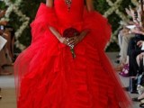 a dramatic strapless hot red wedding ballgown with a ruffle full skirt and an embellished bodice, a red cover up, refined accessories and a black veil