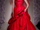 a hot red modern wedding ballgown with a draped bodice and a layered skirt, a train, red shoes and a red veil to make an ultimate statement