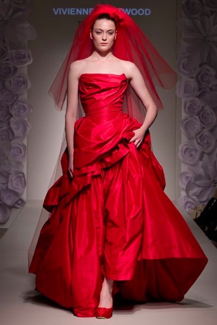 a hot red modern wedding ballgown with a draped bodice and a layered skirt, a train, red shoes and a red veil to make an ultimate statement