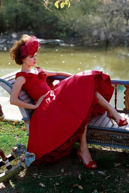 a breathtaking hot red retro wedding dress with a tea-length skirt, a deep neckline with thick straps and red shoes plus a red headpiece