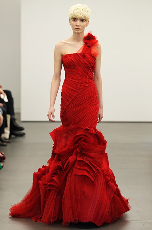 a one shoulder hot red wedding dress with a fabric flower on the shoulder, a draped bodice and a ruffle skirt looks very unusual and makes a statement