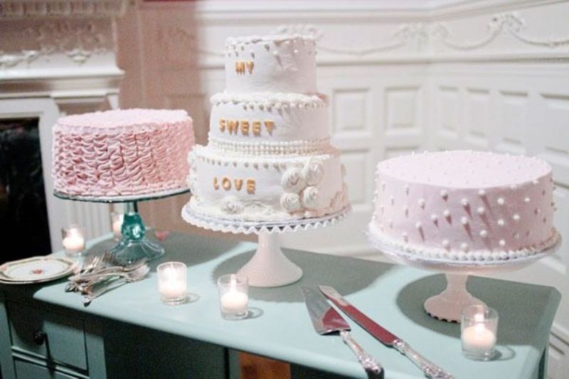 Simple sheer, pink and white cake stands and an assortment of pink and white wedding cakes