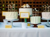 blue, turquoise and wooden cake stands and an assortment of pastel wedding cakes with cute toppers
