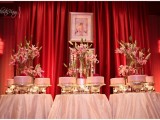 an assortment of pink wedding cakes that are placed on metallic stands and lush floral centerpieces