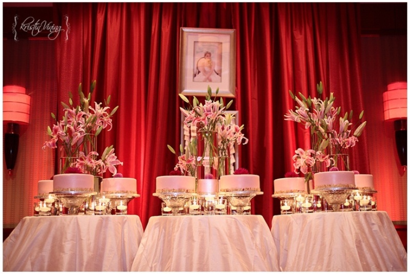 an assortment of pink wedding cakes that are placed on metallic stands and lush floral centerpieces