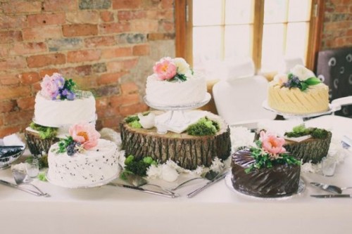 wood stumps and slices plus white stands will make your wedding cake table look rustic