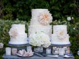 sheer glass cake stands, lace wrapped candleholders and white blooms make the cake table feel rustic