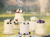 sheer glass cake stands with an assortment of ruffled wedding cakes topped with white and purple blooms