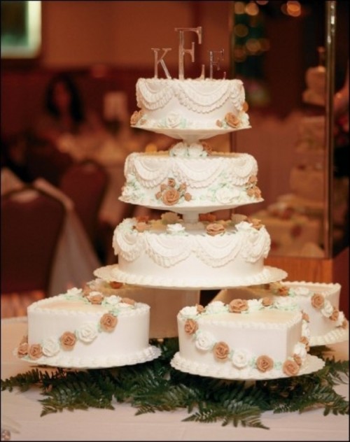 low cake stands and a tiered one to display multiple one-tier wedding cakes at a rustic wedding