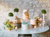 an assortment of wood and metal stands for various wedding cakes and topiaries that settle down one style at this eclectic sweets table