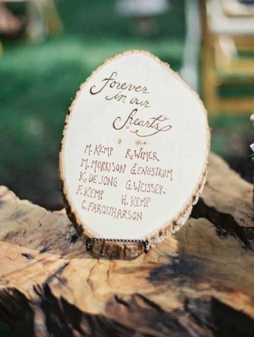 a tree slice with a list of names woodburnt on it is a cool idea for a rustic or woodland wedding, it looks cool and is easy to make