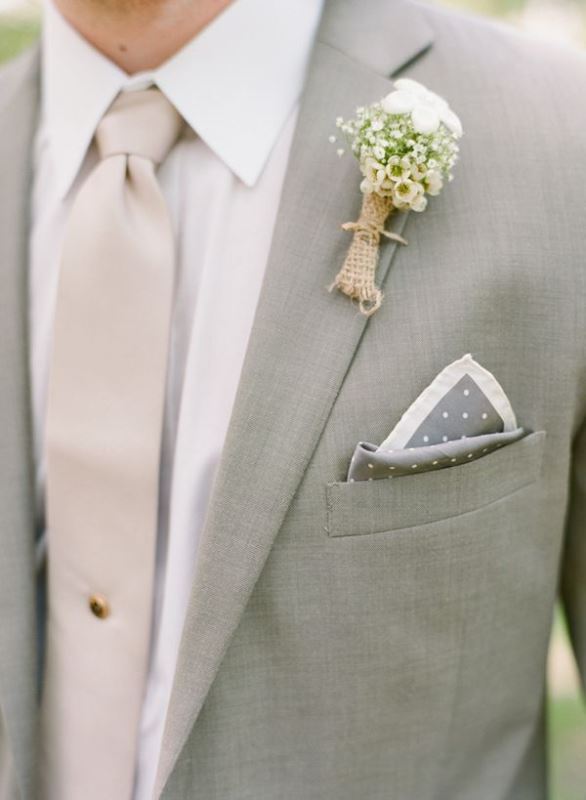A delicate spring groom's look with a light grey suit, a white shirt, a tan tie, a floral boutonniere and a printed handkerchief is a chic idea
