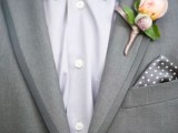 a refined modern groom’s look with a grey suit, a white shirt, a black bow tie, a grey polka dot handkerchief and a delicate floral boutonniere