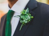 a catchy groom’s look with a black suit, a white shirt, an emerald tie and a bold emerald handkerchief, plus a greenery and succulent boutonniere