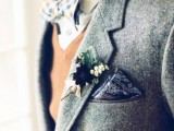 a chic boho groom’s outfit with a white shirt, bold printed bow tie, a tan waistcoat, a grey woolen blazer, a dark printed handkerchief and a floral boutonniere is a stylish idea