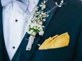 a stylish, bold and catchy groom’s look with a black suit, a white shirt with black buttons, a grey bow tie, a wildflower boutonniere and a yellow handkerchief is a unique combo of formal and relaxed
