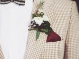 a chic white floral boutonniere with greenery and berries and a burgundy handkerchief that makes the pocket square stylish