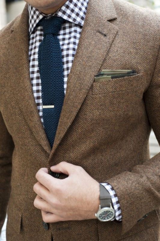 A laconic groom's look with a brown blazer, a printed shirt and a navy tie, a plaid handkerchief to style the pocket square